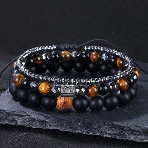 Detail eines dreilagigen Perlenarmbands mit Tigerauge-Steinen und Waage-Sternzeichen-Anhänger