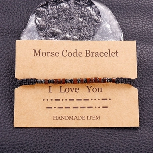 Detail of Morse code bracelet on card featuring I Love You message with wooden beads
