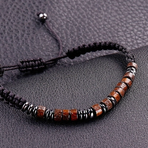 Close-up of Morse code woven bracelet with wooden beads and gray metal accents