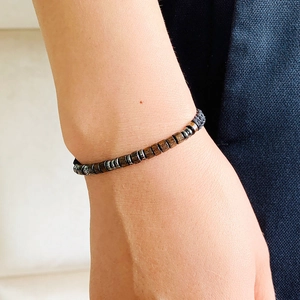 Detailed view of Morse code beaded bracelet with wooden and metallic accents on wrist