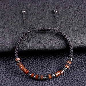 Detailed macro view of adjustable woven bracelet with brown wooden beads and metal spacers