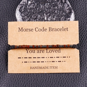 Detail of Morse code bracelet with brown wood beads on handmade woven black cord