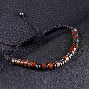Macro detail of adjustable Morse code bracelet with dark wood beads on black leather