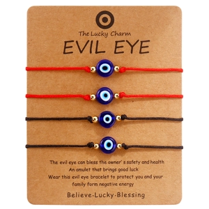 Detail of four handmade Evil Eye braided bracelets on a kraft display card for gifting