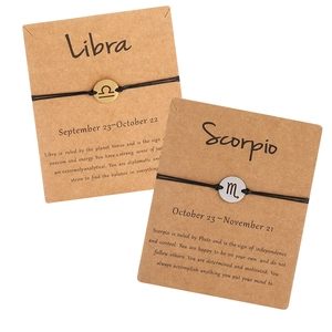 Detail view of woven zodiac bracelets with Libra and Scorpio pendants on display cards