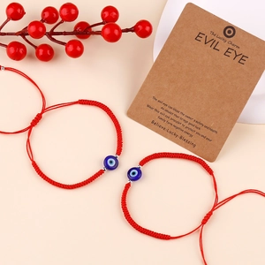 Close-up of red braided Evil Eye bracelets with silver beads and product story card