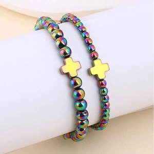 Dettaglio di due braccialetti con perline di ematite arcobaleno e ciondoli a croce