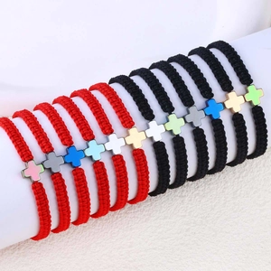 Detail von handgewebten Armbändern mit bunten Kreuzanhängern aus Edelstahl