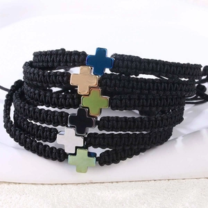 Nahaufnahme verstellbarer geflochtener Armbänder mit bunten Kreuzanhängern aus Edelstahl