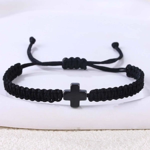 Detailaufnahme von gewebtem schwarzem Seilarmband mit mattem schwarzem Edelstahl-Kreuzanhänger
