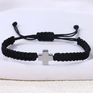 Detailansicht des handgefertigten schwarzen geflochtenen Armbands mit silbernem Kreuz