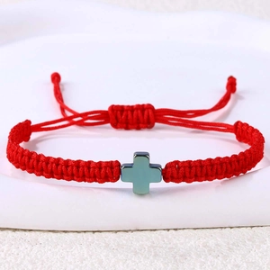 Detail eines roten geflochtenen Armbands mit blauem Hämatit-Kreuz und verstellbarem Knoten