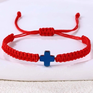 Detail eines roten handgewebten Seilarmbands mit blauem Kreuzanhänger und Schiebeknoten
