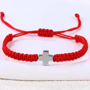 Nahaufnahme eines roten handgewebten Kordelarmbands mit poliertem Silberkreuz