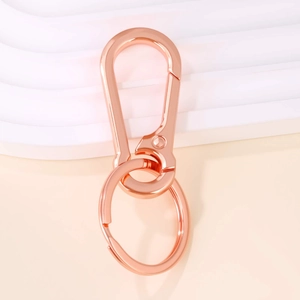 Detailed macro of rose gold metal keychain with spring carabiner clip and flat ring