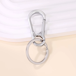 Polished silver metal keychain with carabiner hook and flat ring on white minimalist pedestal