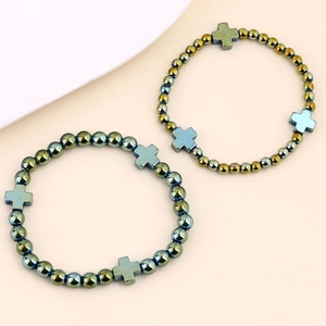 Dettaglio dei bracciali con perline croce in ematite con finitura metallica