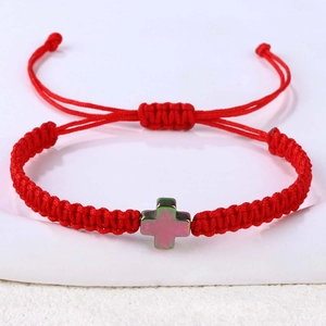 Detailansicht eines handgewebten roten Armbands mit farbenfrohem Kreuzanhänger