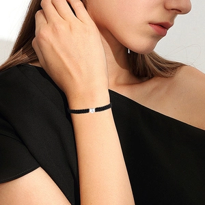 Handmade black woven rope bracelet with a heart-shaped initial A pendant for couples