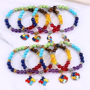 Detail view of eight autism awareness beaded bracelets with natural stones and metal charms
