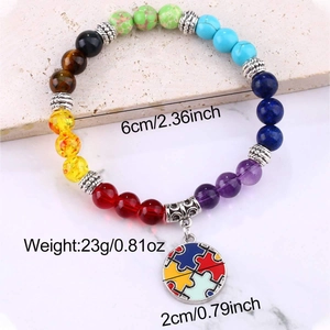 Detail of colorful natural stone bead bracelet with a round puzzle charm and silver spacers