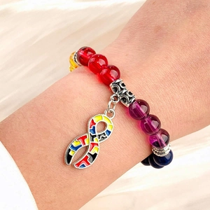 Detail of colorful stone bead bracelet with infinity symbol puzzle charm on wrist