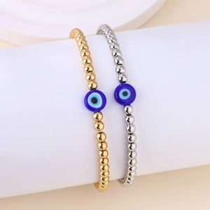 Gouden en zilveren kralenarmbanden met blauwe evil eye glazen bedeltjes set van twee