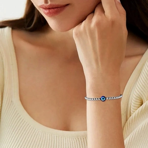 Detailopname van een kralenarmband met het Boze Oog om een vrouwelijke pols