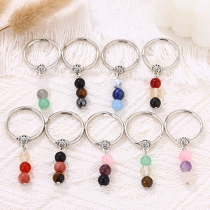 Detailed flat lay of nine natural gemstone beaded keychains with vintage metal caps