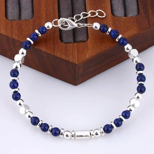 Macro detail of natural stone bead bracelet with silver tube bead and lobster clasp