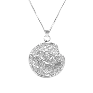 Macro shot of silver zodiac pendant with textured edges and artistic relief on cable chain