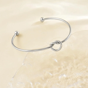 Dettaglio di un bracciale a nodo in acciaio inossidabile argento lucido con punte a sfera