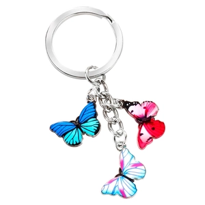 Detail of silver keychain ring with three colorful butterfly charms in blue and pink tones