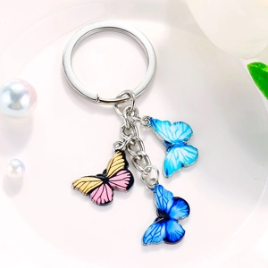 Cute metal keychain with three colorful enamel butterfly pendants on a silver ring