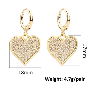 Golden heart drop earrings with pavé set cubic zirconia stones on white background
