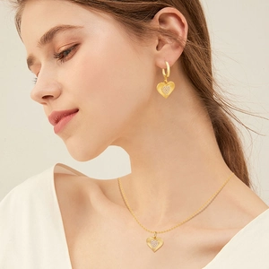 Detail of heart jewelry set featuring brushed gold finish and sparkling pave zircons