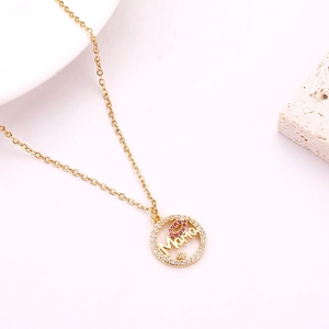 Detail of gold Mama necklace with red lips motif and sparkling crystal border