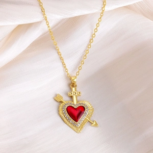 Dettaglio della collana con ciondolo a cuore dorato, smalto rosso e intarsi di zirconi