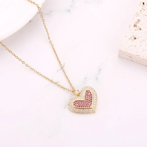 Detailed close-up of a gold heart necklace with micro-set pink and white zircon stones