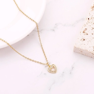 Detailed macro view of a gold heart necklace with sparkling zircon stones in lifestyle setting
