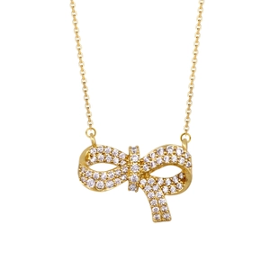 Macro shot of gold-plated bow necklace pendant featuring pavé set white gemstones