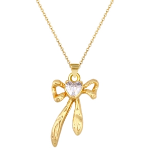 Detailed view of gold bow pendant necklace with a heart-shaped crystal center