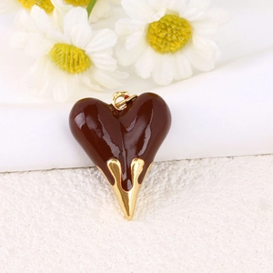 Colgante de corazón minimalista en marrón chocolate y acabado dorado sobre fondo de tela blanca