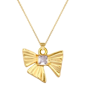Macro detail of gold bow pendant necklace featuring a square-cut zircon and pleated texture