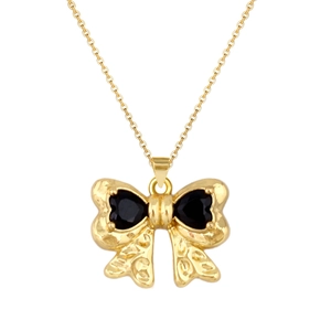 Detail of vintage gold bow pendant featuring two black heart-shaped gemstones and fine texture
