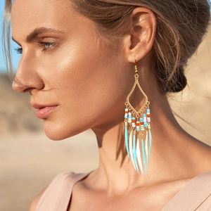 Close-up of Bohemian geometric drop earrings with colorful beads and feather charms