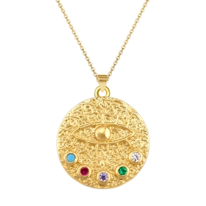 Detail of gold evil eye pendant necklace with colorful gemstones and hammered texture
