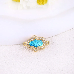 Detalle del colgante de tortuga marina chapado en oro con opalo azul y circonitas blancas