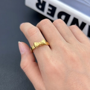 Dettaglio ravvicinato dell'anello a fiocco dorato con una finitura lucida elegante