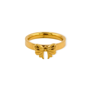 Dettaglio dell'anello dorato con fiocco minimalista e finitura in acciaio inossidabile lucido